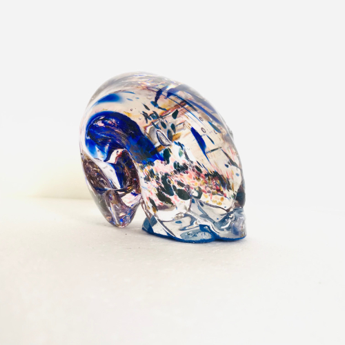 A product picture of an artesanal crafted sculpture made of glass. It has an abstract splattering of colours within it's form.